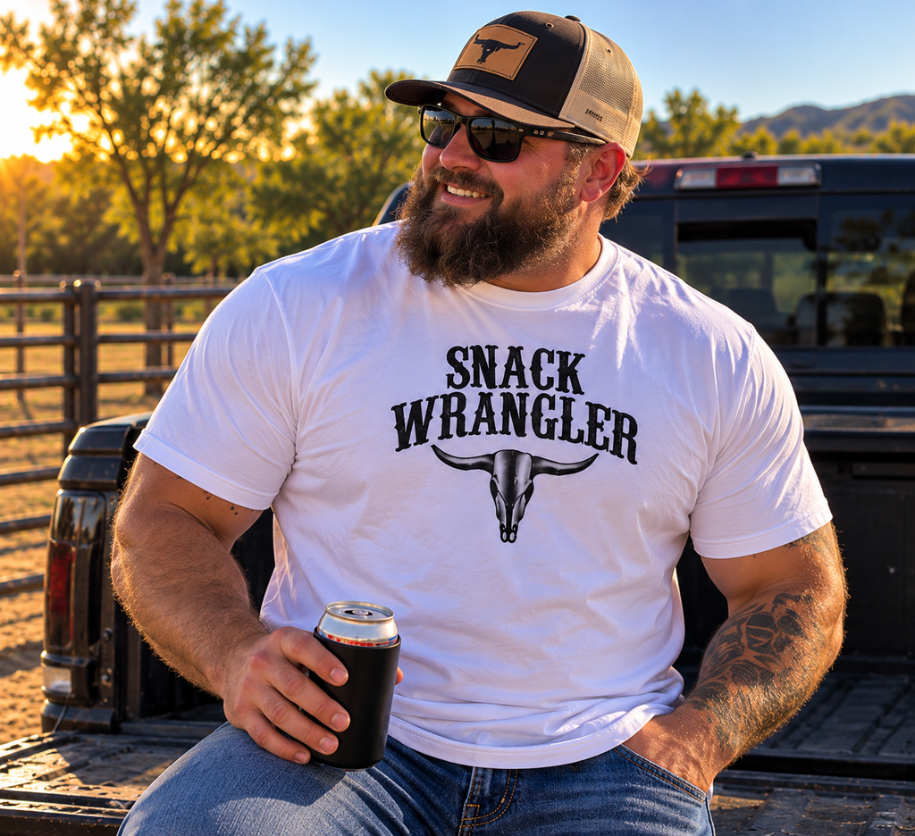 Bearded man in white Snack Wrangler tee beside pickup